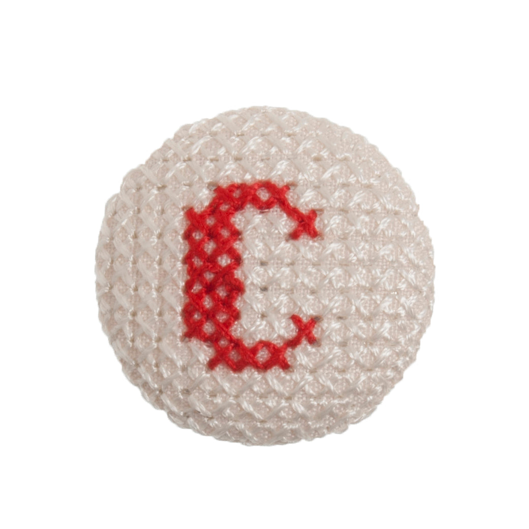 Round button with a red cross-stitch letter C