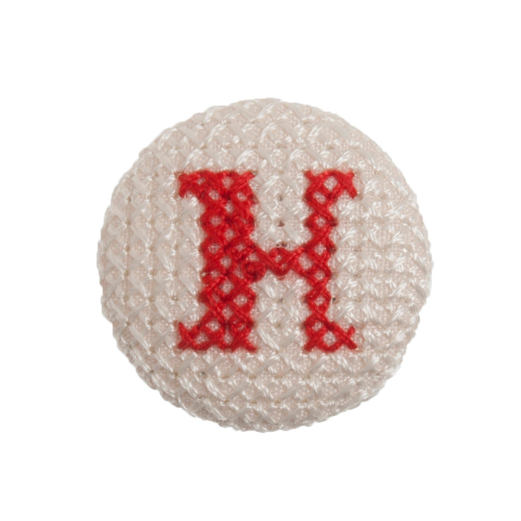 Round button with a red cross-stitch letter H