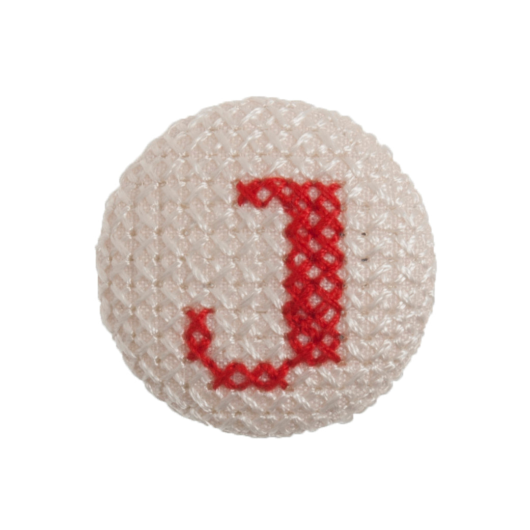 Round button with a red cross-stitch letter J