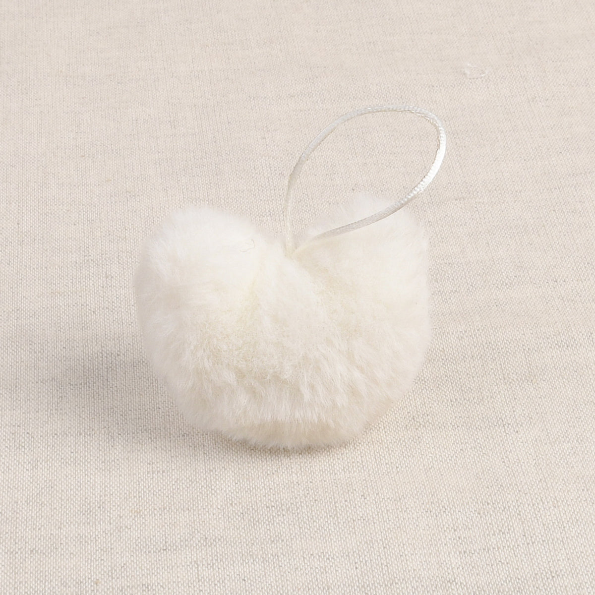 Off White faux fur heart-shaped pom pom with a hanging loop