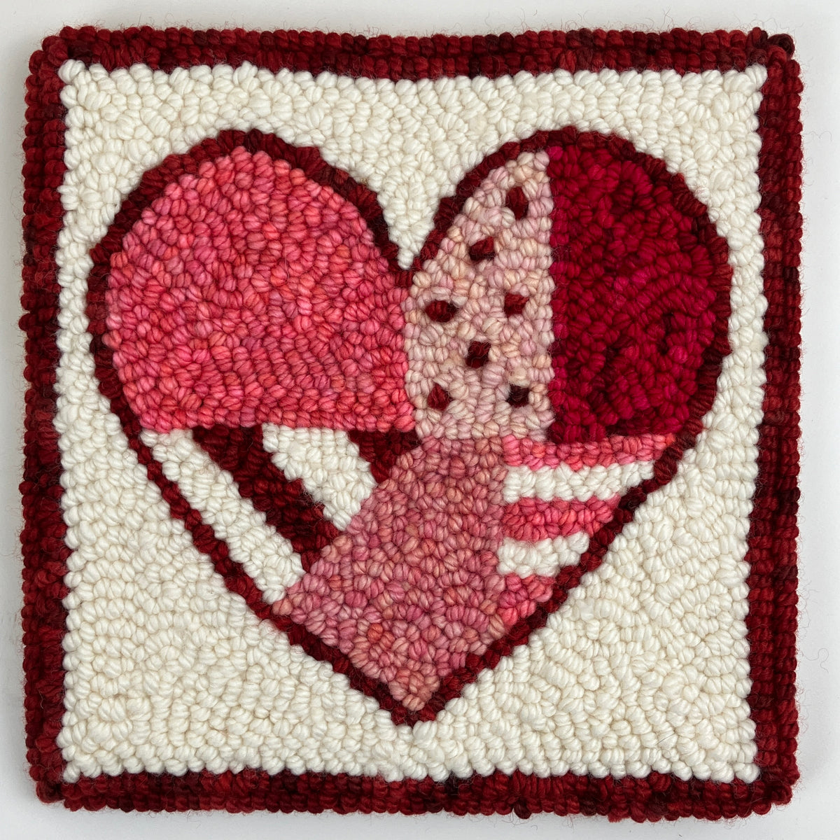 Finished red patchwork heart punch needle design in wool yarn