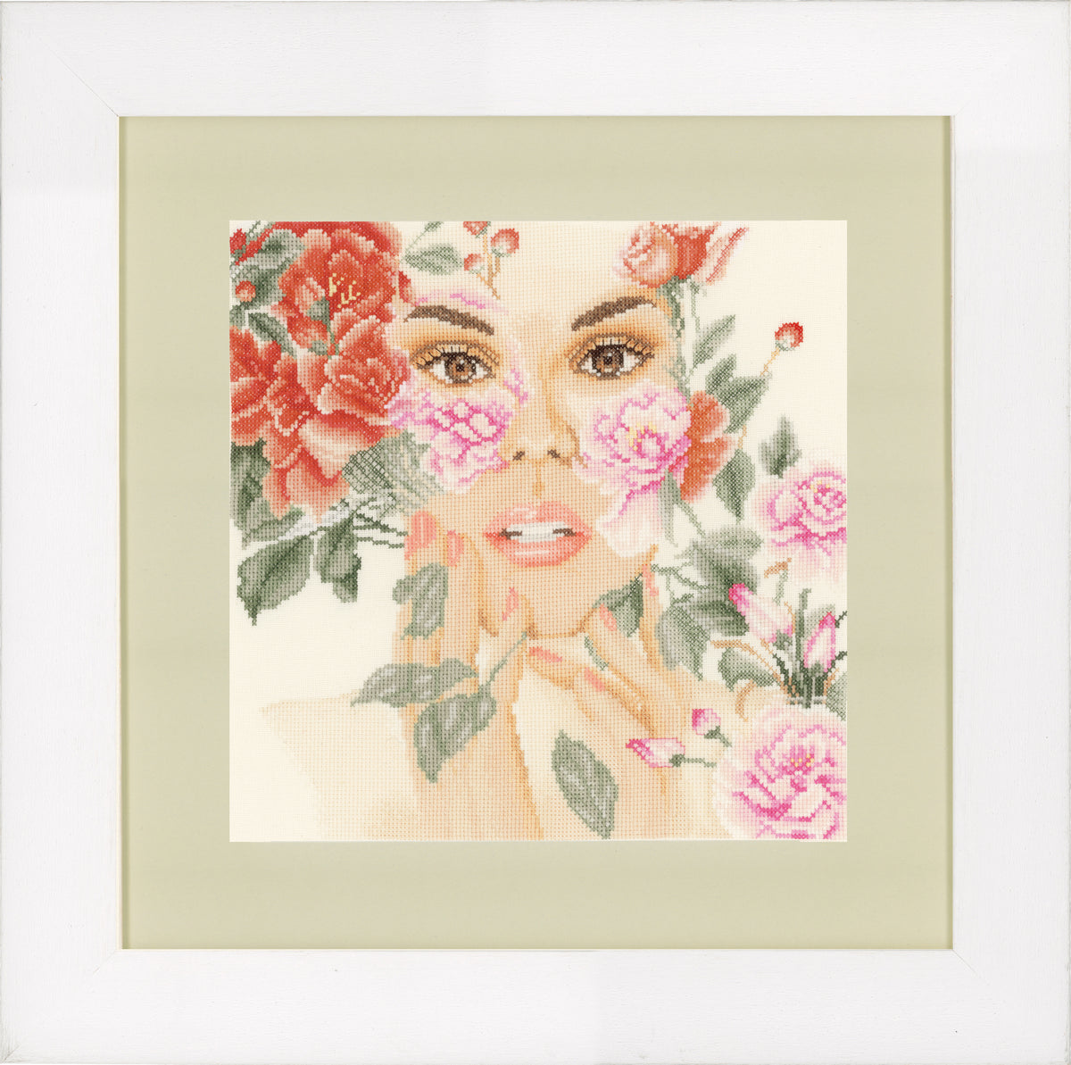 Cross stitch design of a face surrounded by flowers