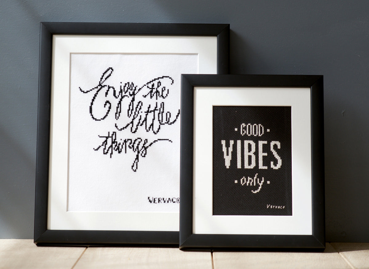 Cross stitched Enjoy the Little Things design on black fabric