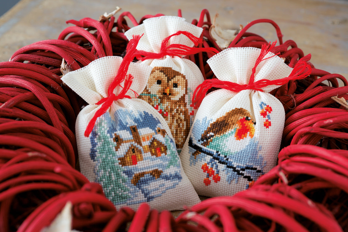 Three cross stitched winter gift bags