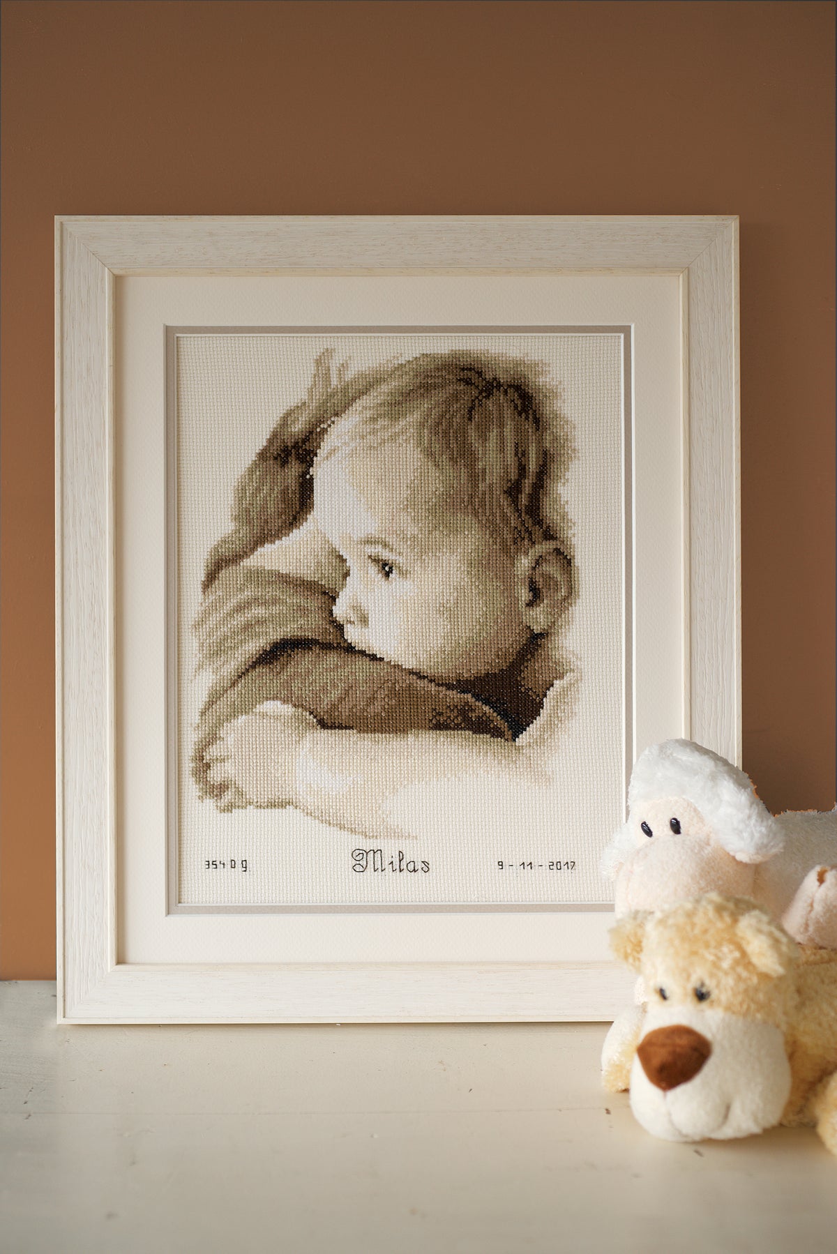 Cross stitch birth record with a baby hug design