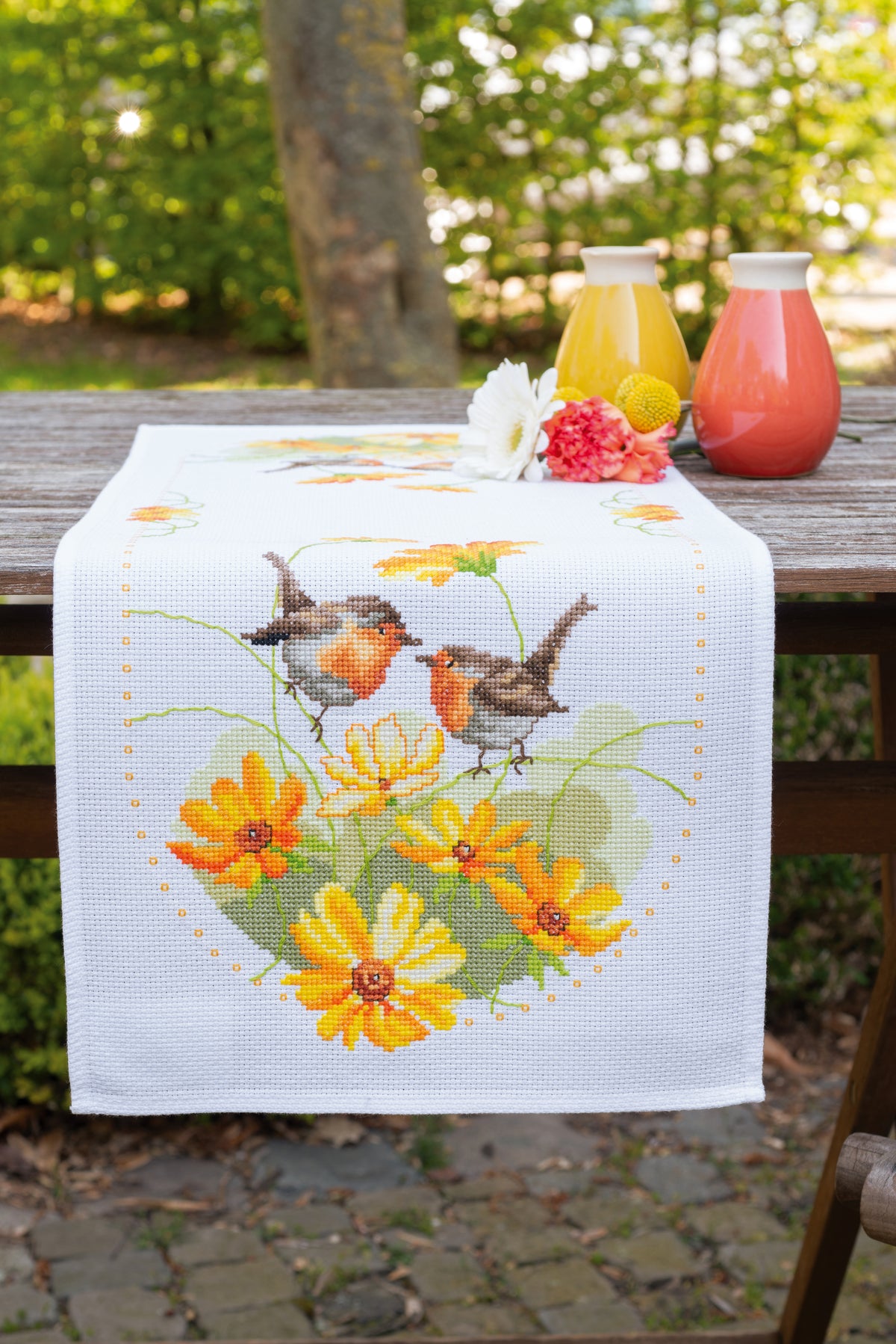 Cross stitched table runner with robins and flowers