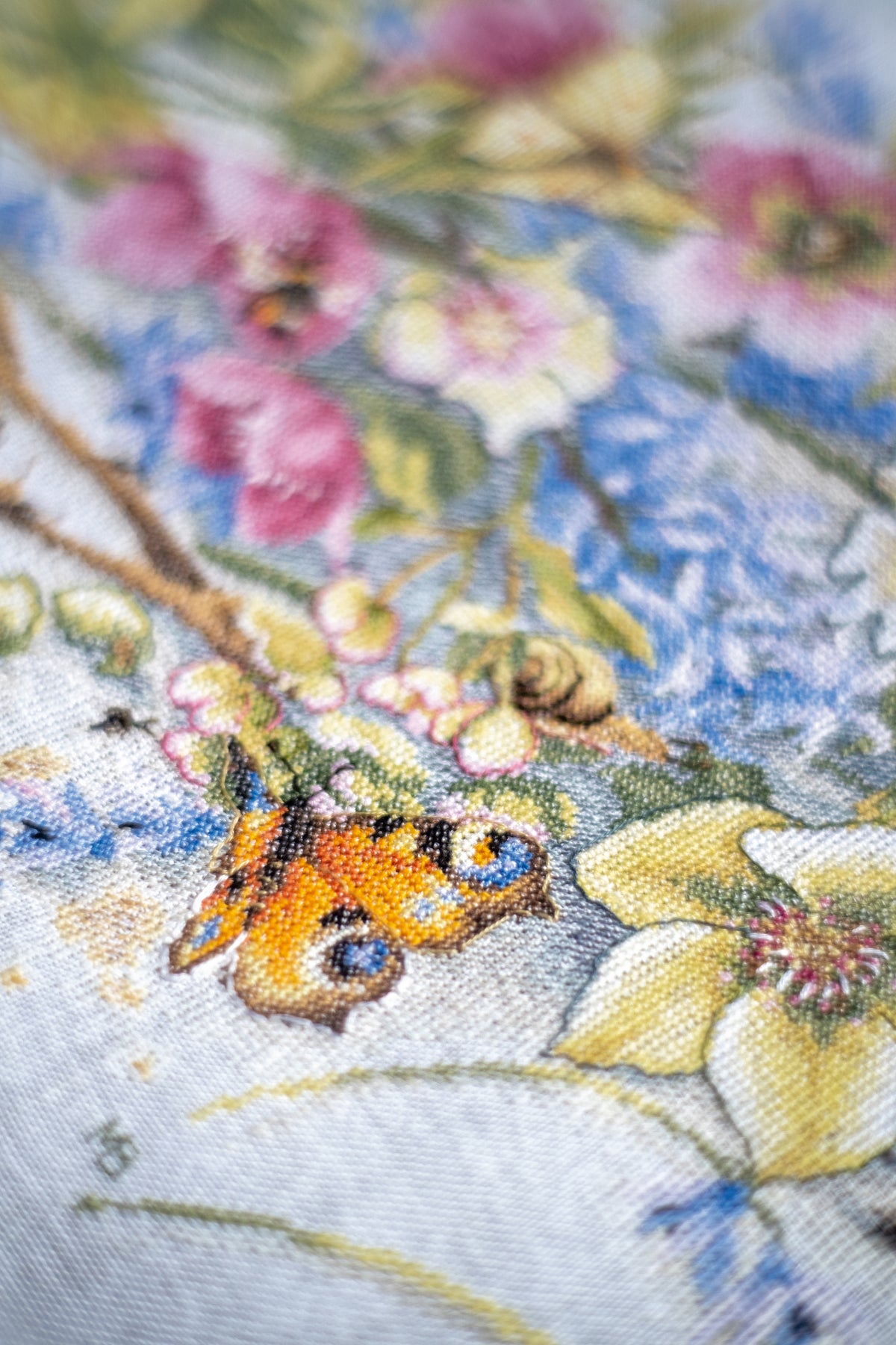Cross stitch picture of hellebore flowers on linen