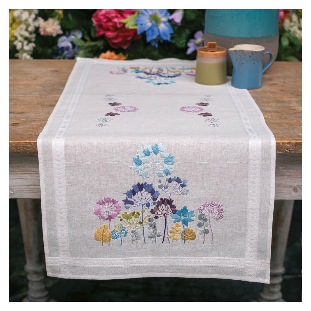 White table runner embroidered with blue and purple allium flowers