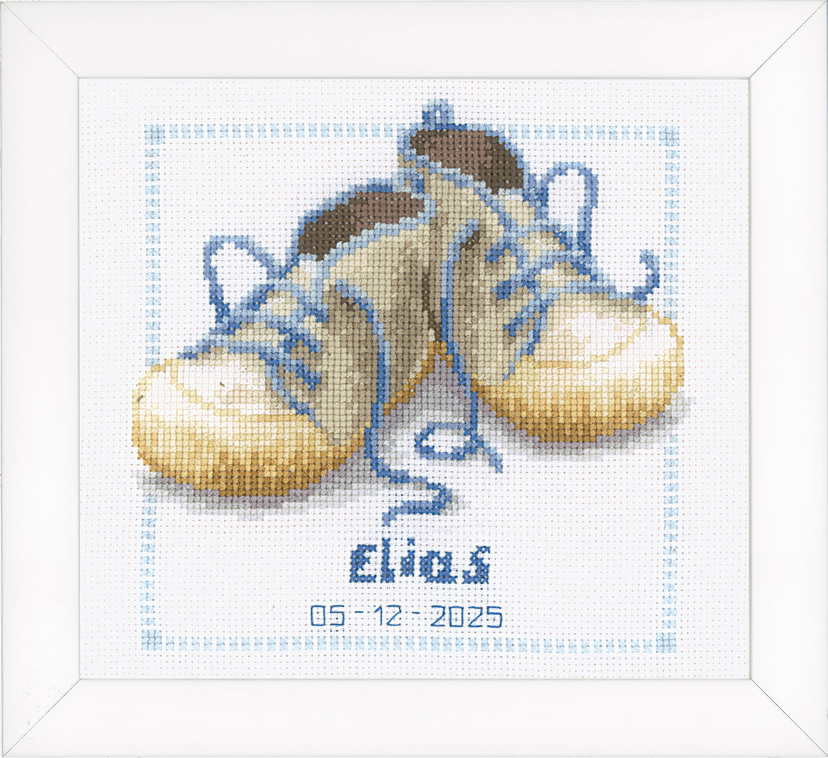 Cross stitched birth record with a pair of baby shoes