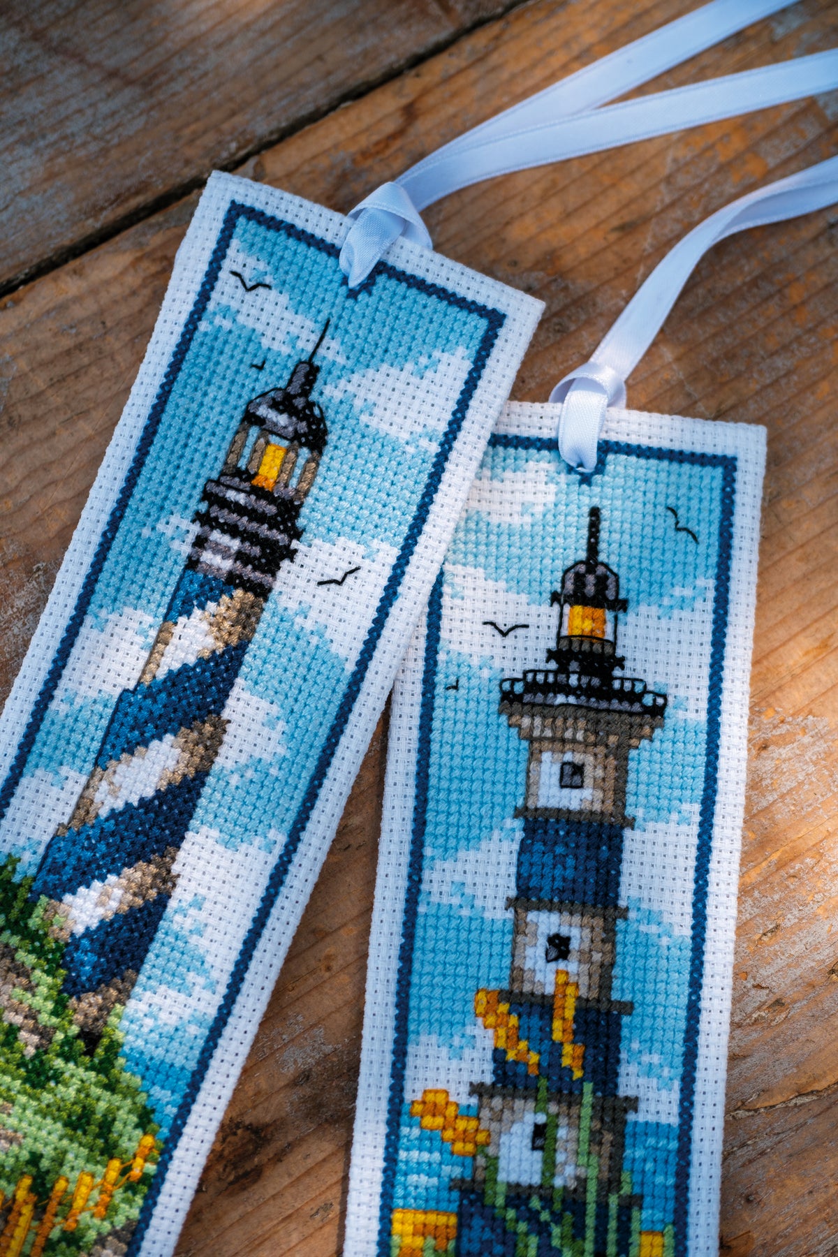 Two cross stitched bookmarks with lighthouse designs