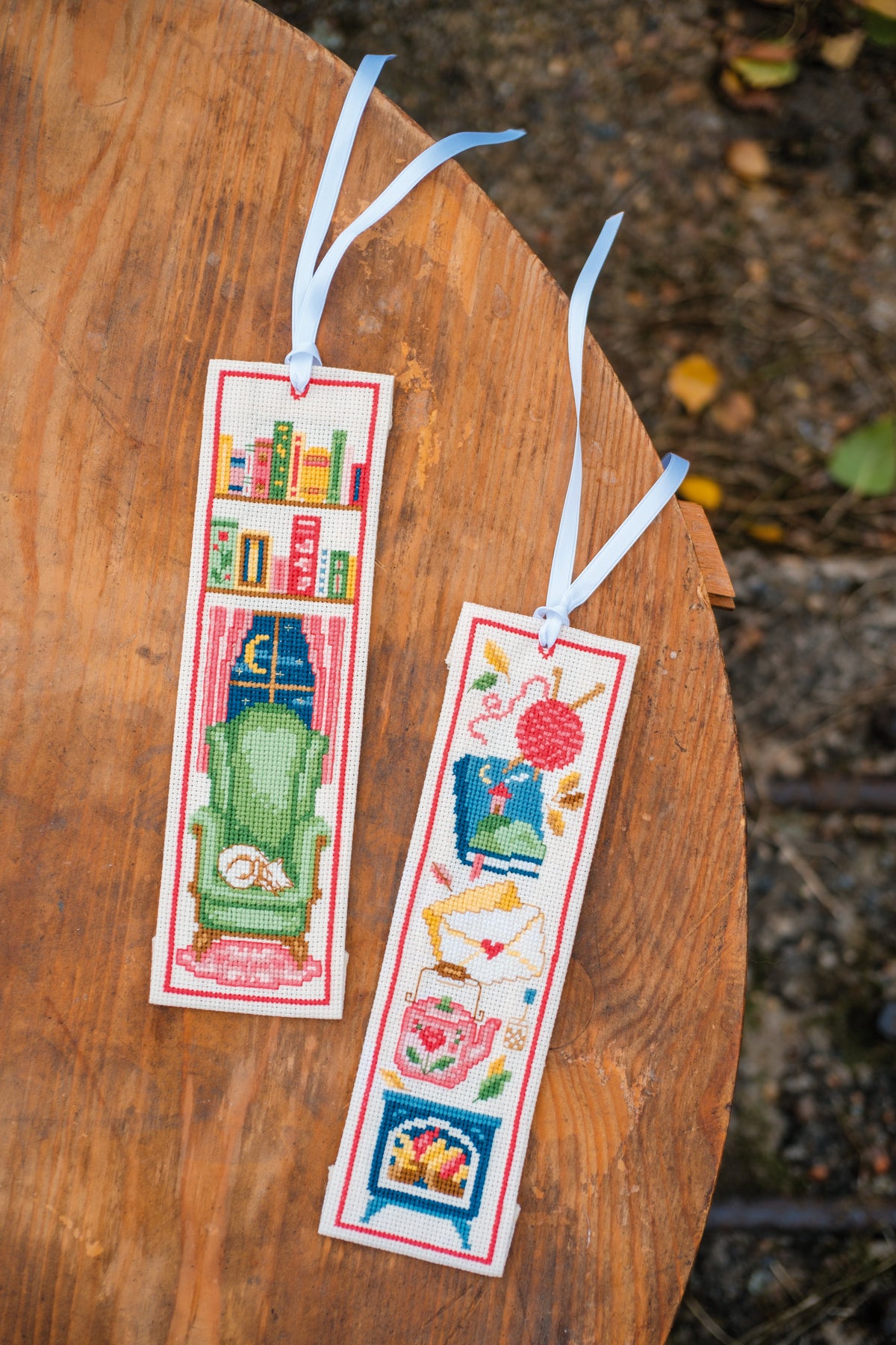 Two cross stitched bookmarks with cosy reading designs