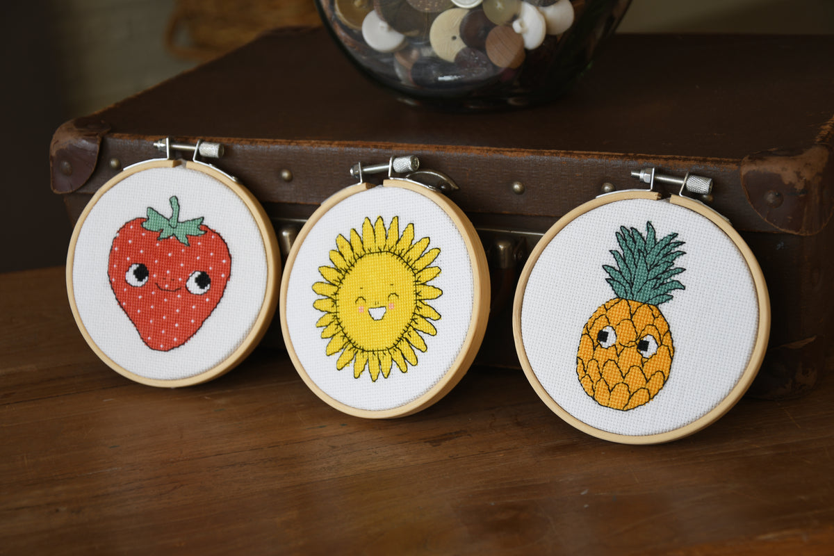 Eva Mouton pineapple cross stitch design in an embroidery hoop