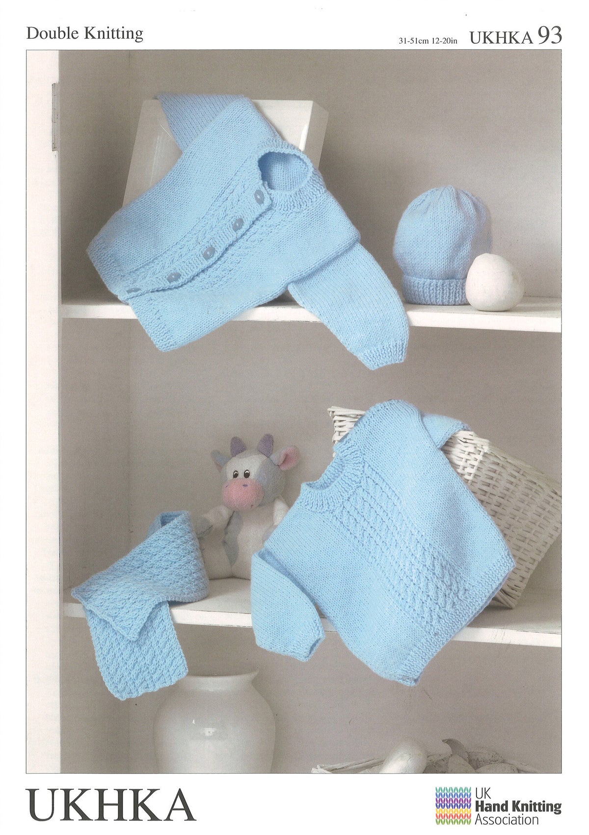 Knitting pattern cover showing a baby sweater, cardigan, hat and scarf