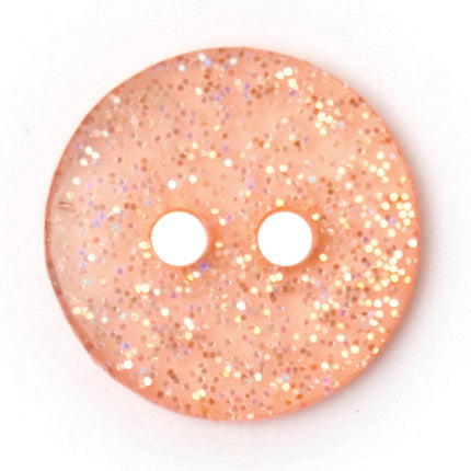 Peach round button with silver glitter set into a clear finish