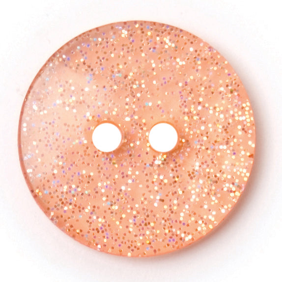Peach round button with silver glitter set into a clear finish