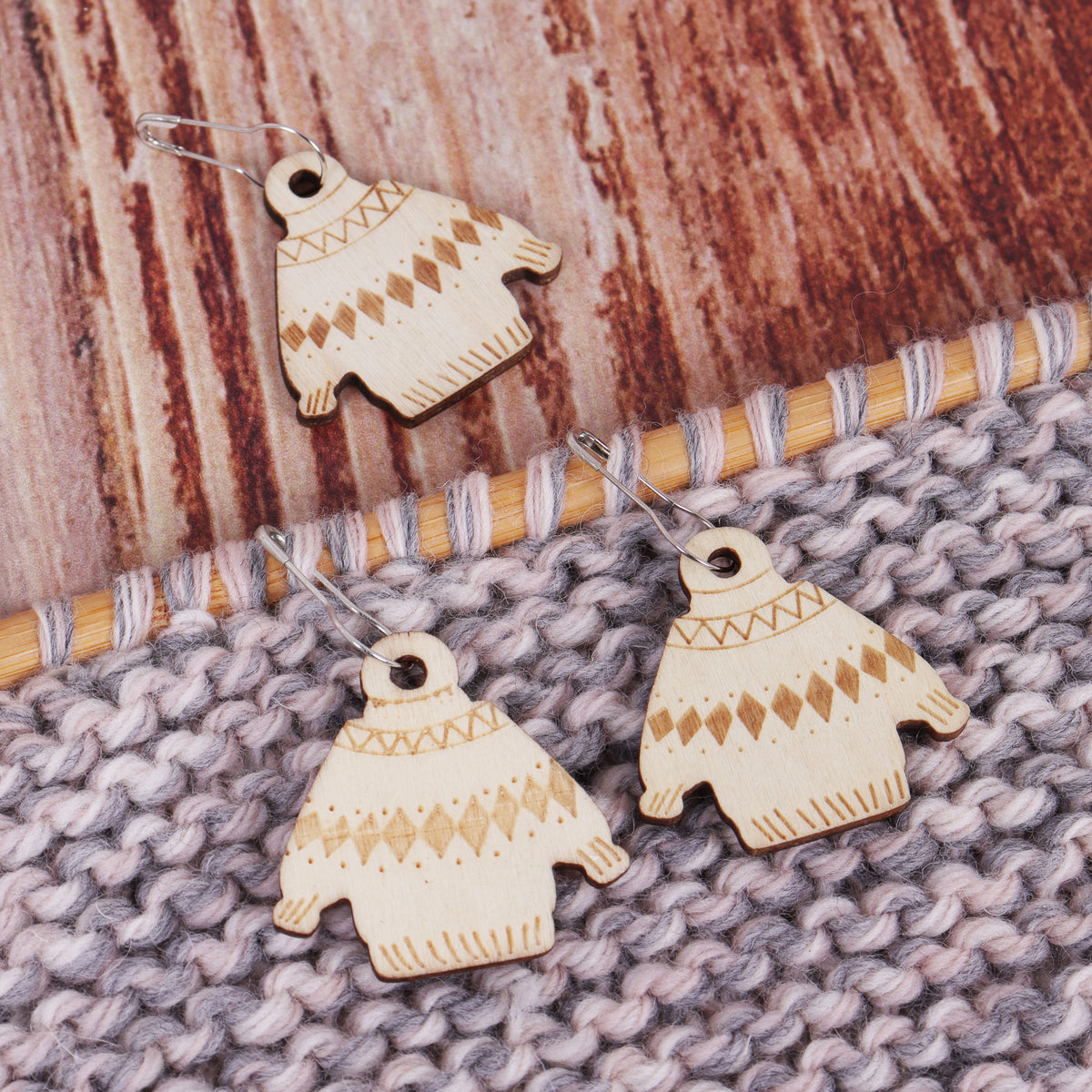 Tub of wooden woolly jumper stitch markers on bulb pins