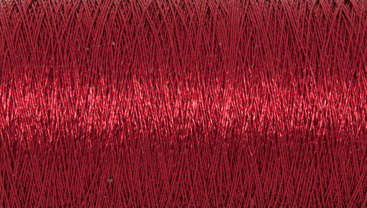 Close-up of red metallic thread wound on a spool