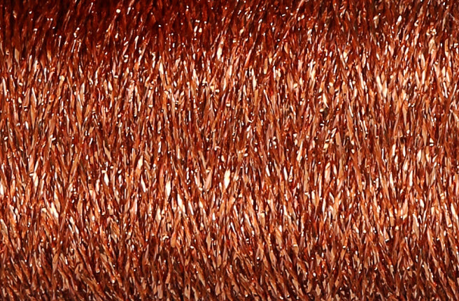 Close-up of copper metallic thread wound on a spool