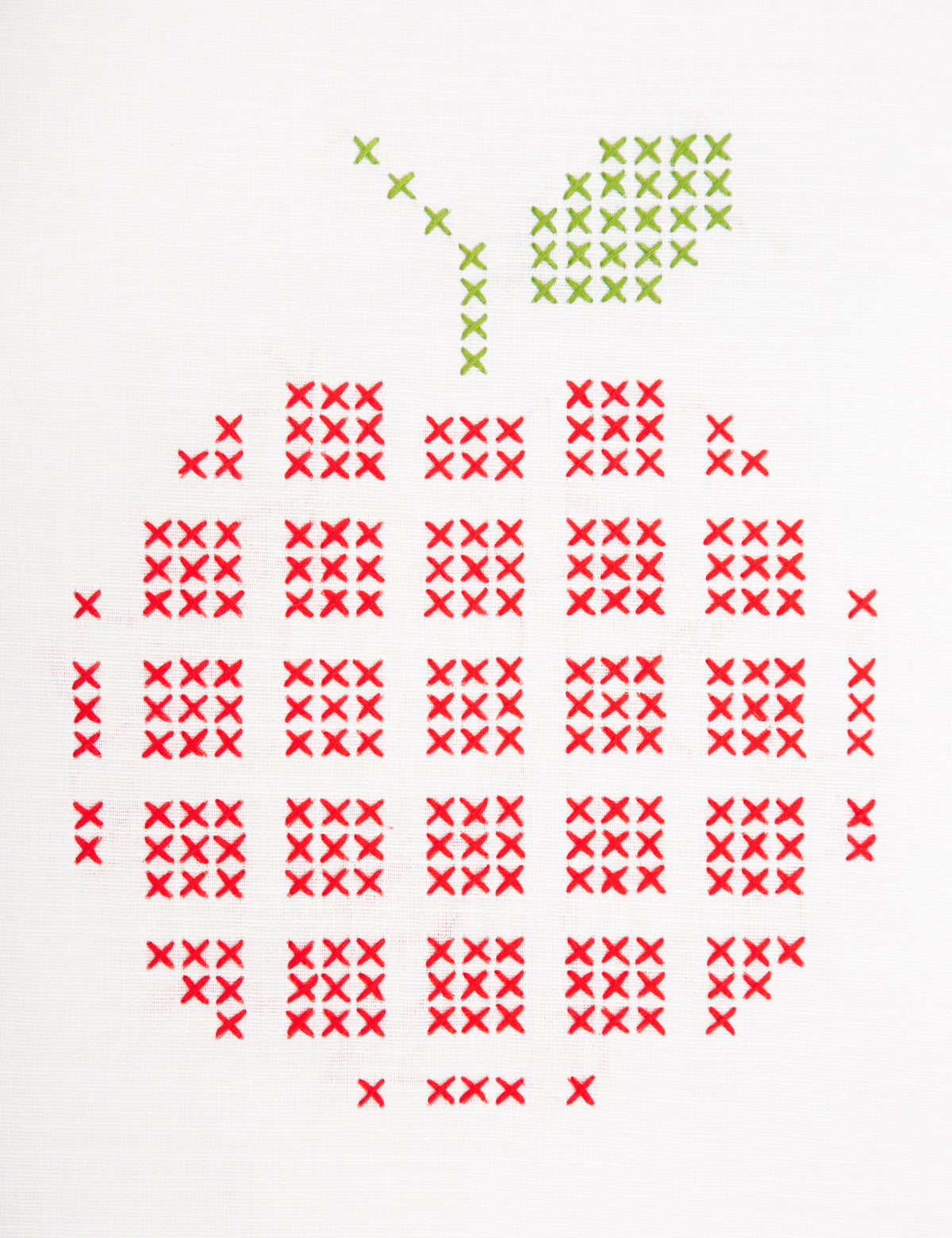 Embroidered apple design on white fabric
