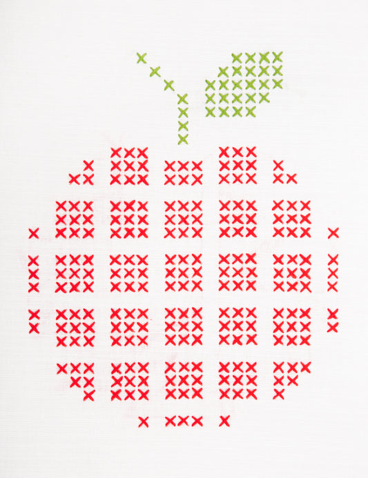 Embroidered apple design on white fabric