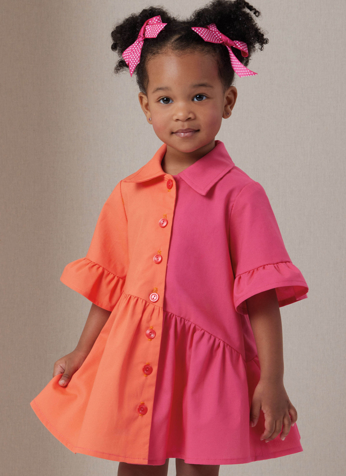 Butterick B7049 sewing pattern envelope showing toddler button-front dress designs