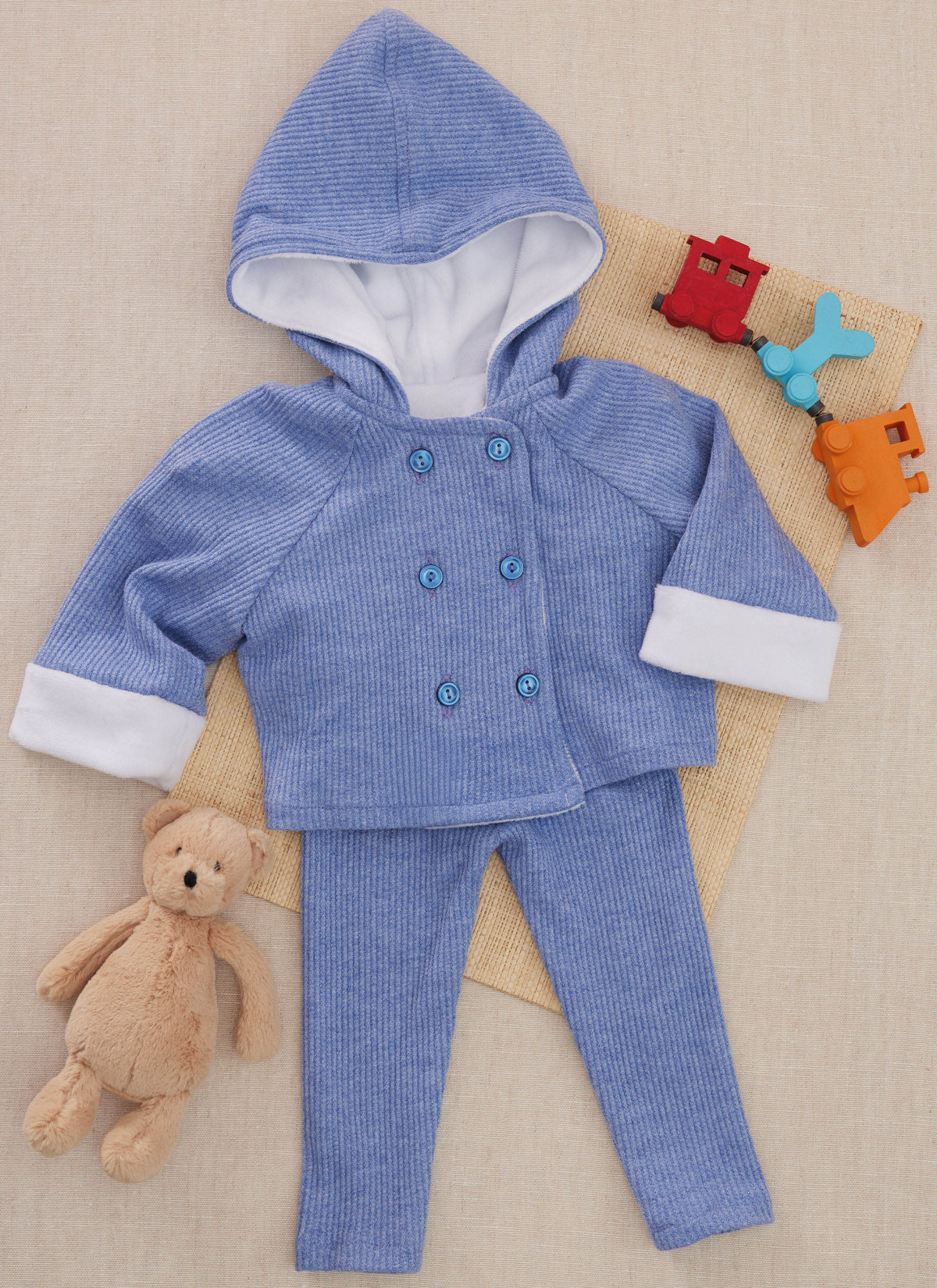 Butterick B7066 sewing pattern envelope showing a baby coat and leggings set