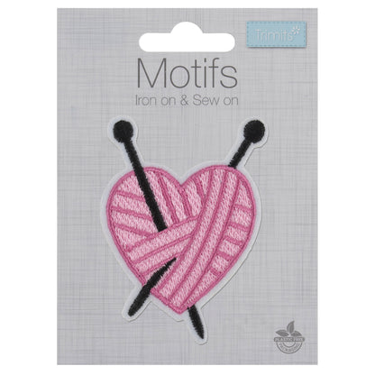 Pink yarn heart motif with black knitting needles