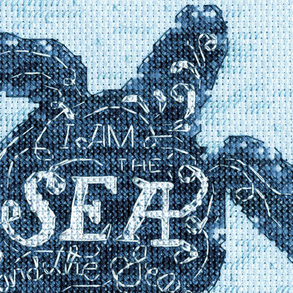 Finished sea turtle cross stitch on blue fabric