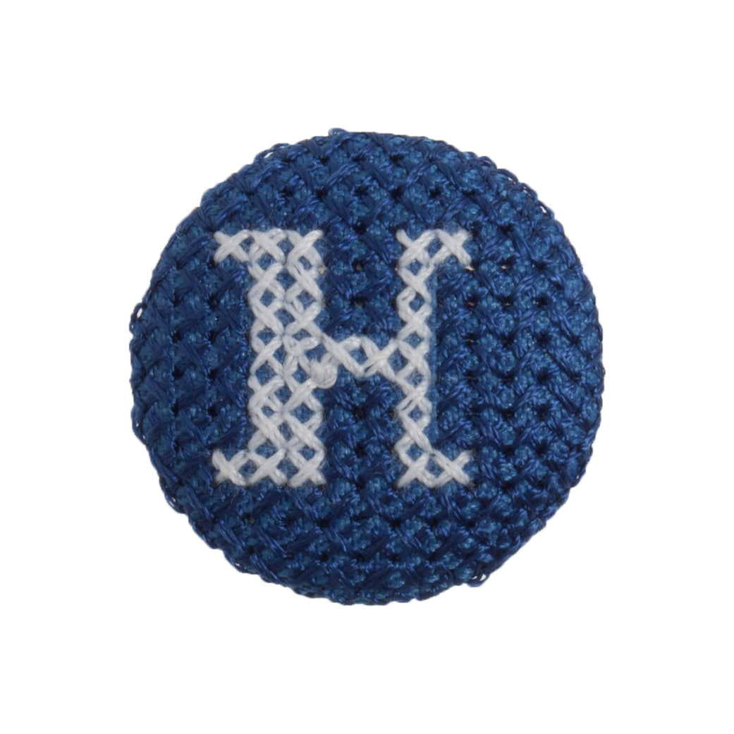 Round button with a blue cross stitch letter H