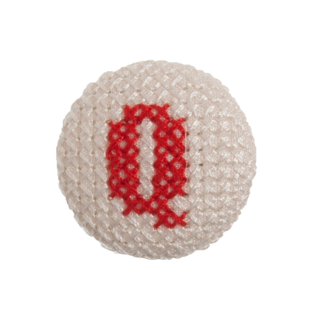 Round button with a red cross-stitch letter Q