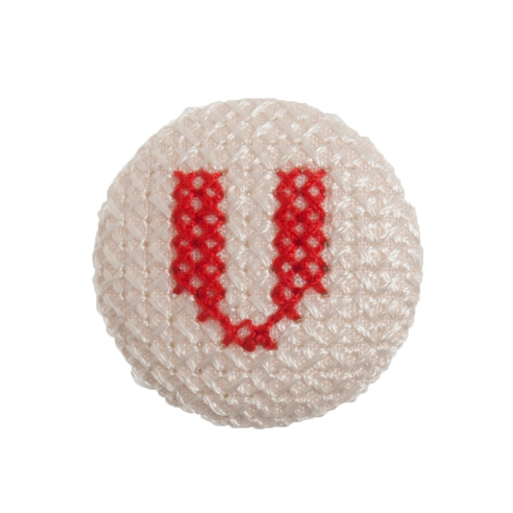 Round button with a red cross-stitch letter V