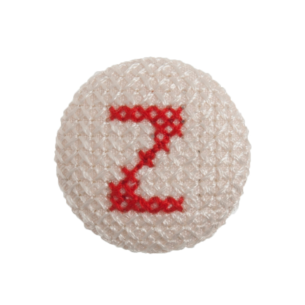 Round button with a red cross-stitch letter Z