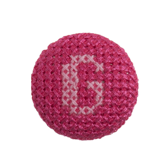 Round button with a fuchsia cross stitch letter G