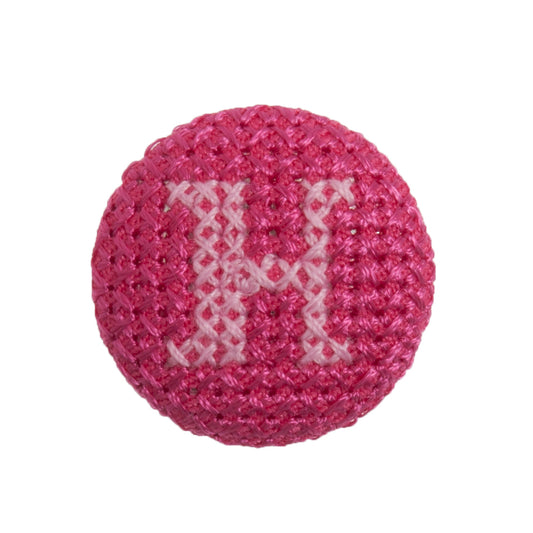 Round button with a fuchsia cross stitch letter H