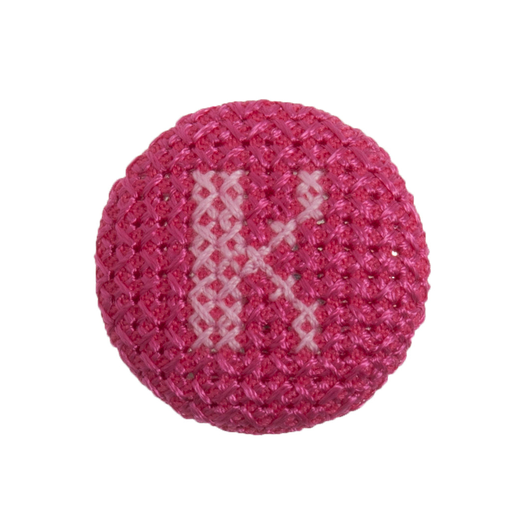 Round button with a fuchsia cross stitch letter K