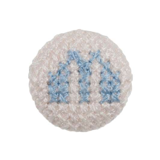 White fabric-covered button with a light blue cross-stitched letter M