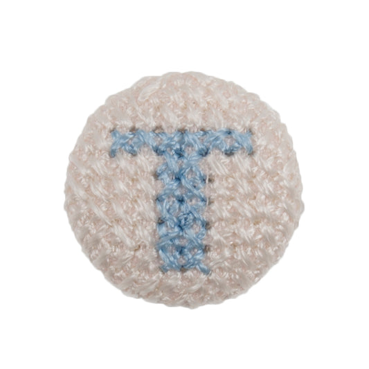 White fabric-covered button with a light blue cross-stitched letter T