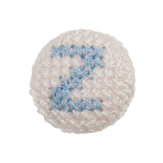 White fabric-covered button with a light blue cross-stitched letter Z