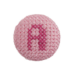 Pink fabric-covered button with a darker pink cross-stitched letter A