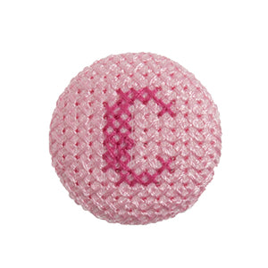 Pink fabric-covered button with a darker pink cross-stitched letter C