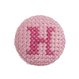 Pink fabric-covered button with a darker pink cross-stitched letter H