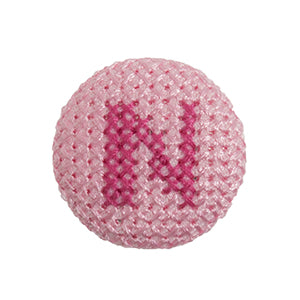Pink fabric-covered button with a darker pink cross-stitched letter N