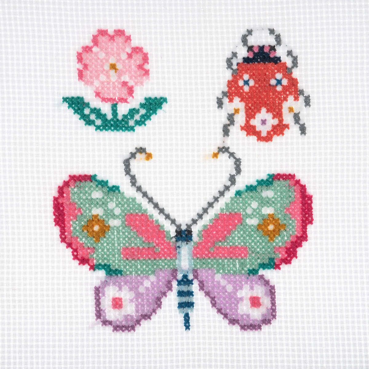 Trimits mini cross stitch kit showing a butterfly and a little bug