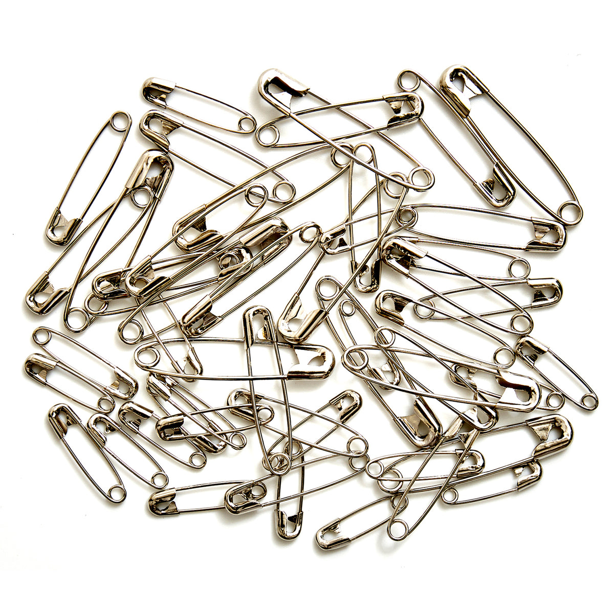 Glass jar of assorted silver safety pins