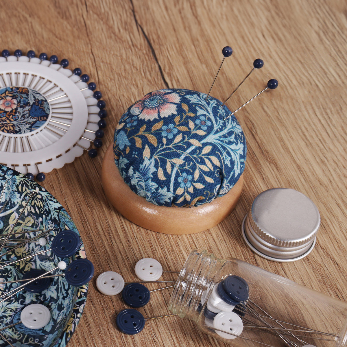 Round fabric pin cushion on a wooden base
