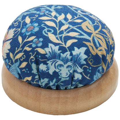 Round fabric pin cushion on a wooden base
