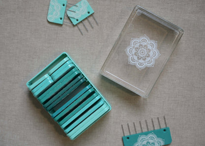 Teal mandala knit blockers with stainless steel pins and storage case
