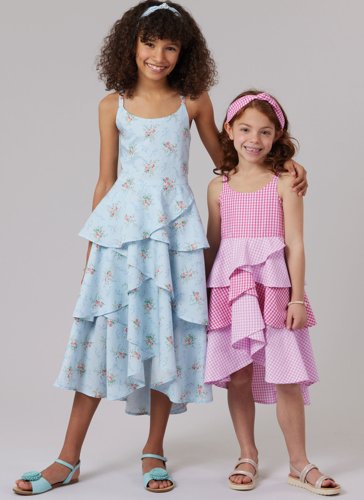 McCall's M8592 sewing pattern envelope showing girls' layered dresses designs