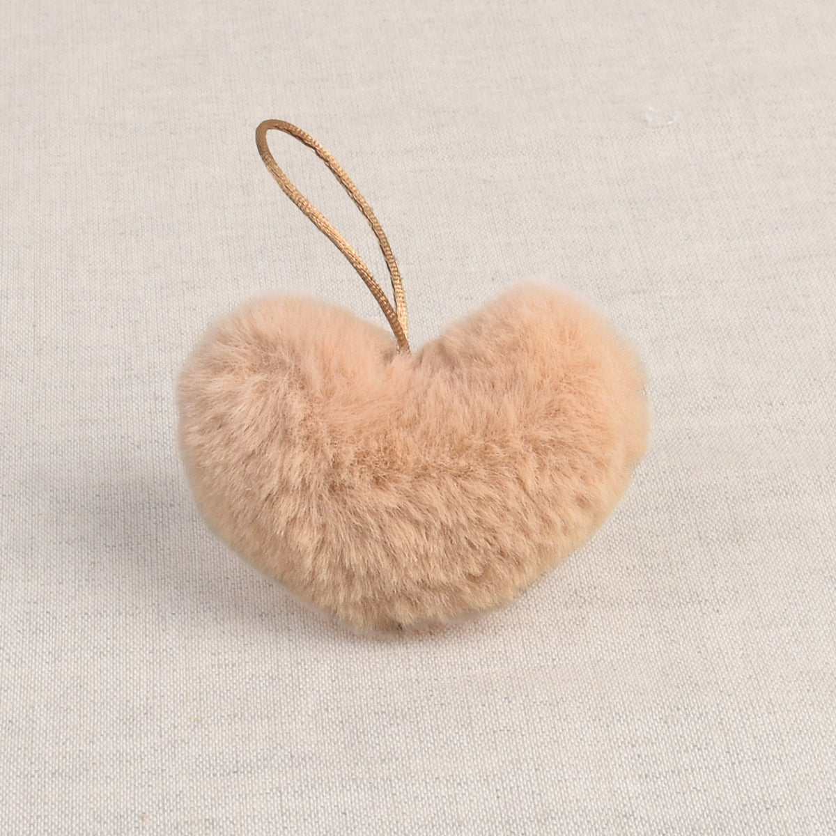 Beige faux fur heart-shaped pom pom with loop