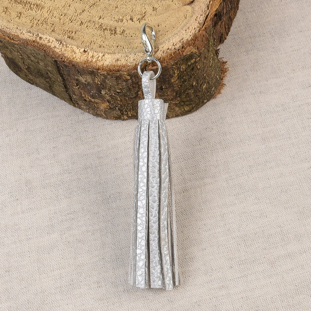 Silver tassel with a fastener at the top